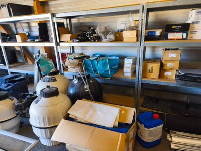 une pièce où il y a beaucoup de cartons et d'autres objets sur les étagères