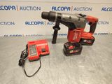 a corded drill and two batteries sitting on a table