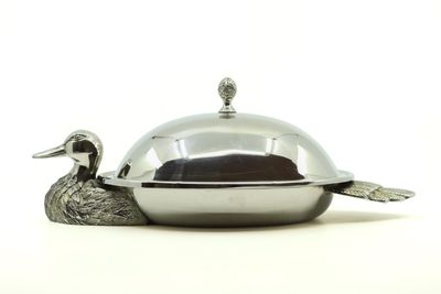 une assiette en argent sur laquelle est posé un canard