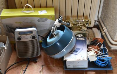 un mixeur bleu posé sur le sol à côté d'une boîte de câbles