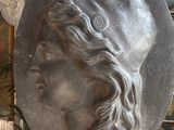a sculpture of a woman ' s head hanging from the ceiling