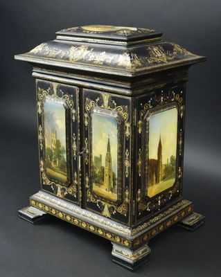 une armoire peinte en noir et or, surmontée d'une horloge