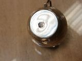 a silver vase on a table with a brown table cloth