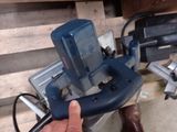a person holding a tool in their hand near a pile of wood