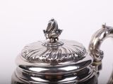 a silver tea pot with a lid on a table