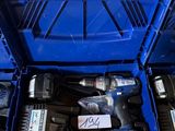 Deux outils électriques se trouvent dans une boîte bleue posée par terre.