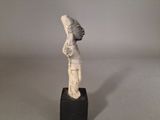 an ancient statue of a man with a hat on his head