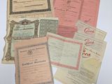 Plusieurs anciens certificats sont posés sur une table avec un fond blanc