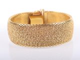 a close up of a gold bracelet on a white surface