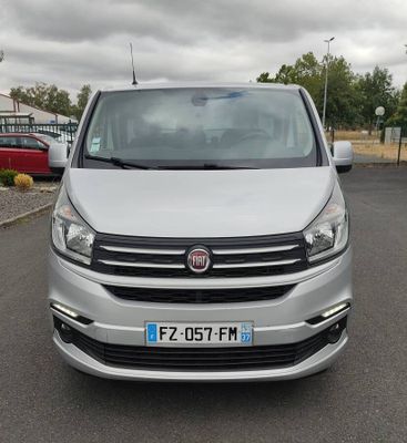 vue de face d'une camionnette argentée garée sur un parking