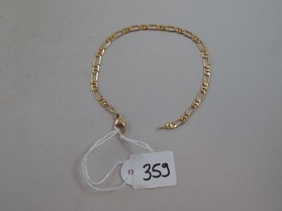 un gros plan sur un bracelet en chaîne dorée muni d'une étiquette de prix
