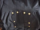 a black jacket with gold buttons on it sitting on a table