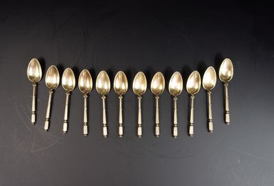 six cuillères en argent alignées sur une surface noire