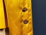 a close up of a yellow jacket with buttons on a mannequin mannequin mannequin mannequin mannequin mannequin mannequin