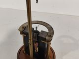 a small metal device with a wooden base on a white surface