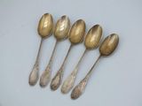 six silver spoons sitting on top of a white surface