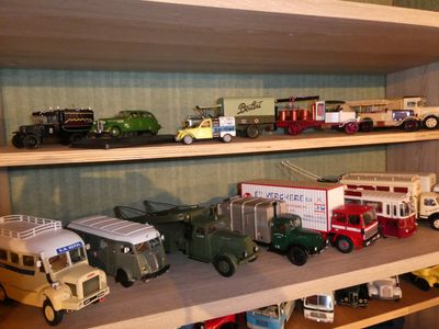 many toy cars and trucks on a shelf in a room