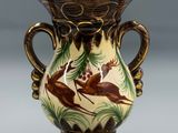 un vase orné d'un motif de cerf, posé sur une table