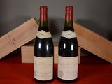 two bottles of wine sitting next to each other on a table