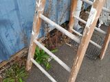 a ladder leaning against a blue wall next to a toilet