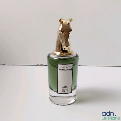 gros plan d'un flacon de parfum sur une surface blanche