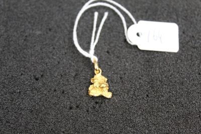 a close up of a gold necklace with a tag on it