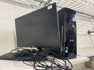 un ordinateur de bureau posé sur une table avec un clavier et une souris