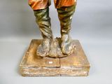 a figurine of a man with a hat and boots on top of a box