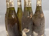 four bottles of wine are lined up in a row on a table