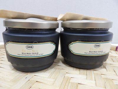 two jars of blueberry jam with a wooden spoon sitting on a table