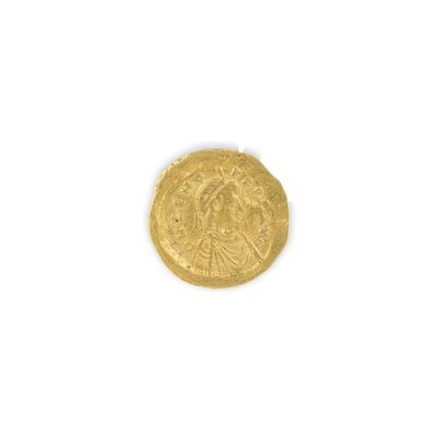 gros plan d'une pièce d'or sur une surface blanche
