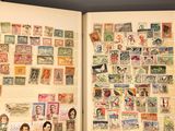an open book with stamps on it sitting on a table