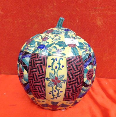 un vase décoratif posé sur une table, sur fond rouge