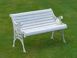 a white bench sitting in the middle of a grassy field