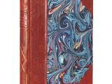 un vieux livre avec une couverture bleue et rouge sur fond blanc