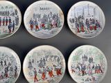 four plates with different designs of people on them on a table
