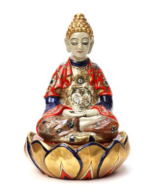 statue of a buddha sitting on a lotus flower with a cat in his lap