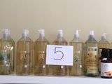de nombreuses bouteilles de liquide posées sur une étagère à côté d'un miroir