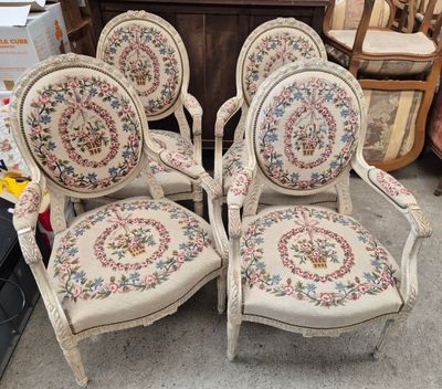 four chairs with floral upholstered cushions are sitting in front of a dresser