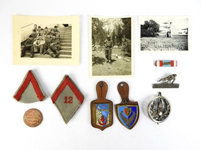 Plusieurs insignes et épinglettes militaires sont disposés sur un fond blanc