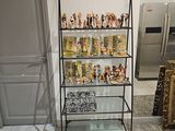 une étagère en verre sur laquelle sont disposées des figurines, dans une pièce