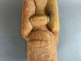 statue of a man sitting on a chair with his arms crossed
