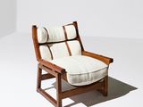 une image représentant une chaise avec un coussin posé dessus, dans une pièce blanche
