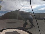 a reflection of a skateboarder on the hood of a car