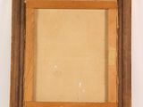 an old picture frame hanging on a wall with a white wall in the background