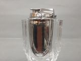 un vase en verre muni d'un couvercle en argent, posé sur une table