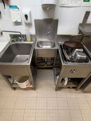 two sinks in the kitchen with pots and pans on them