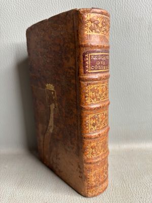 an old book sitting on top of a table next to a white wall