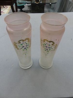 two vases sitting on a table with a white table cloth