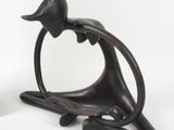 a statue of a bird sitting on a branch next to a vase